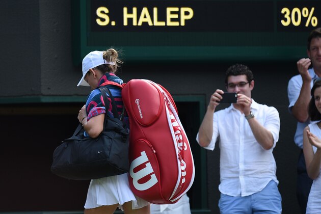 Romania's Simona Halep leaves the court after losing to Taiwan's Hsieh Su-Wei in their women's singles third round match on the sixth day of the 2018 Wimbledon Championships at The All England Lawn Tennis Club in Wimbledon, southwest London, on July 7, 2018. (Photo by Oli SCARFF / AFP) / RESTRICTED TO EDITORIAL USE        (Photo credit should read OLI SCARFF/AFP/Getty Images)