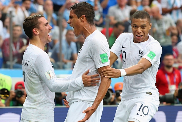 NIZHNY NOVGOROD, RUSSIA - JULY 06:  Raphael Varane of France celebrates with team mates Kylian Mbappe and Antoine Griezmann after scoring his team's first goal during the 2018 FIFA World Cup Russia Quarter Final match between Winner Game 49 and Winner Game 50 at Nizhny Novgorod Stadium on July 6, 2018 in Nizhny Novgorod, Russia.  (Photo by Alex Livesey/Getty Images)