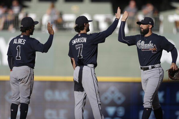 Atlanta Braves' Nick Markakis, right, high-fives Dansby Swanson (7) and Ozzie Albies (1) after a baseball game against the Milwaukee Brewers, Saturday, July 7, 2018, in Milwaukee. The Braves won 5-1. (AP Photo/Aaron Gash)