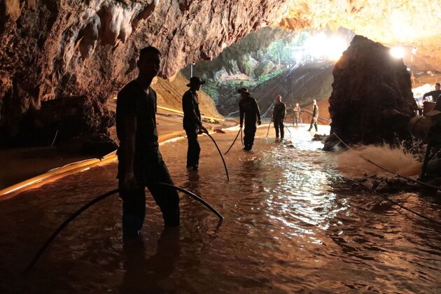In this undated photo released by Royal Thai Navy on Saturday, July 7, 2018, Thai rescue teams arrange water pumping system at the entrance to a flooded cave complex where 12 boys and their soccer coach have been trapped since June 23, in Mae Sai, Chiang Rai province, northern Thailand. The local governor in charge of the mission to rescue them said Saturday that cooperating weather and falling water levels over the last few days had created appropriate conditions for evacuation, but that they won't last if it rains again.. (Royal Thai Navy via AP)