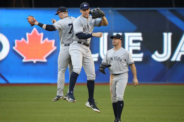 TORONTO, ON - JULY 7: Aaron Judge #99 of the New York Yankees celebrates their victory with Clint Frazier #77 and Brett Gardner #11 during MLB game action against the Toronto Blue Jays at Rogers Centre on July 7, 2018 in Toronto, Canada. (Photo by Tom Szczerbowski/Getty Images)