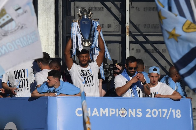 Manchester City's Belgian defender Vincent Kompany holds up the Premier League trophy to fans as the Manchester City team take part in an open-top bus parade through Manchester, northern England on May 14, 2018 to celebrate winning the 2018 Premier League title. - Manchester City set the seal on a record-breaking season by becoming the first side in English top flight history to hit 100 points with victory at Southampton on Sunday. City also added another landmark by winning the league by a record 19 points from local rivals Manchester United. (Photo by Paul ELLIS / AFP)        (Photo credit should read PAUL ELLIS/AFP/Getty Images)