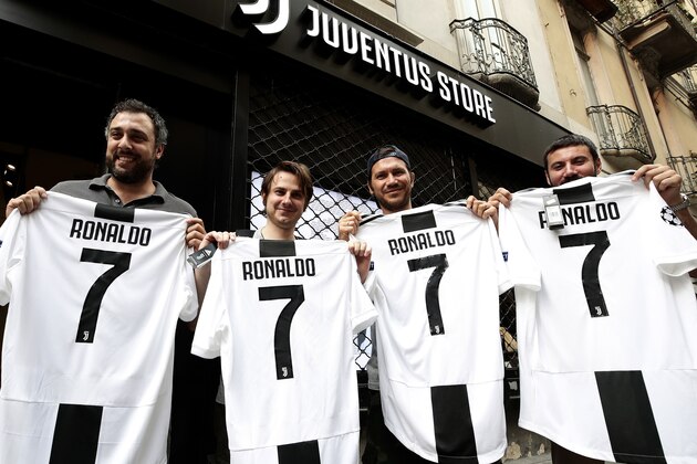 Juventus' supporters show their Cristiano Ronaldo's Juventus official Jerseys in front of the Juventus store on July 10, 2018 in Turin after Real Madrid announced today the transfer of Ronaldo to Italy's Juventus, with the Portuguese superstar saying the time had come 'for a new stage' in his life. - Real Madrid did not give any details as to the amount of the transfer but Spanish media reports have said it could reach 105 million euros ($120 million), with the 33-year-old signing a four-year contract worth 30 million euros per season. (Photo by Isabella Bonotto / AFP)        (Photo credit should read ISABELLA BONOTTO/AFP/Getty Images)