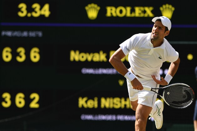 Serbia's Novak Djokovic serves to Japan's Kei Nishikori during their men's singles quarter-finals match on the ninth day of the 2018 Wimbledon Championships at The All England Lawn Tennis Club in Wimbledon, southwest London, on July 11, 2018. (Photo by Glyn KIRK / AFP) / RESTRICTED TO EDITORIAL USE        (Photo credit should read GLYN KIRK/AFP/Getty Images)