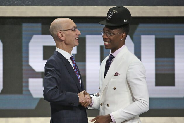 Miami's Lonnie Walker IV, right, shakes hands with NBA Commissioner Adam Silver after he was picked 18th overall by the San Antonio Spurs during the NBA basketball draft in New York, Thursday, June 21, 2018. (AP Photo/Kevin Hagen)