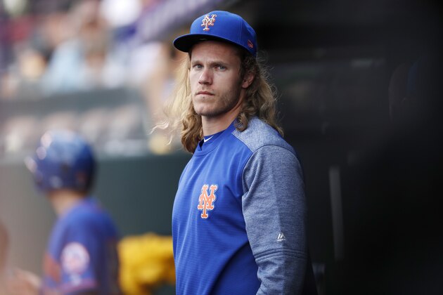 Injured New York Mets pitcher Noah Syndergaard watches from the dugout during the first inning of the team's baseball game against the Colorado Rockies on Wednesday, June 20, 2018, in Denver. (AP Photo/David Zalubowski)