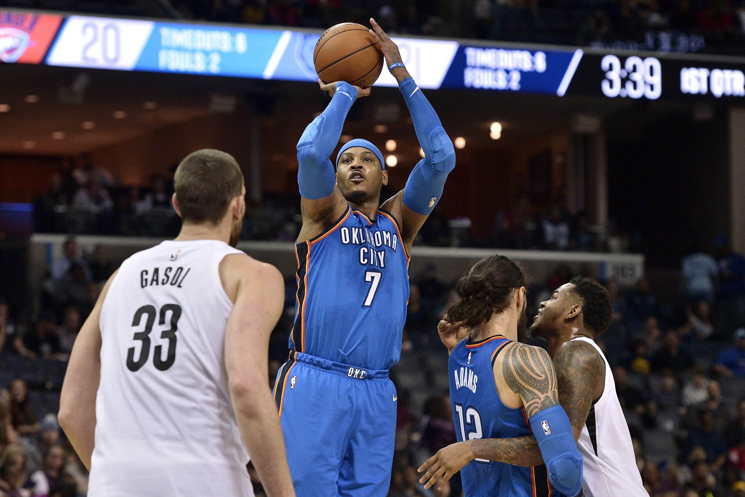 Oklahoma City Thunder forward Carmelo Anthony (7) shoots ahead of Memphis Grizzlies center Marc Gasol (33) as Thunder center Steven Adams (12) and Grizzlies forward Jarell Martin, far right, move for position in the first half of an NBA basketball game Wednesday, Feb. 14, 2018, in Memphis, Tenn. (AP Photo/Brandon Dill)