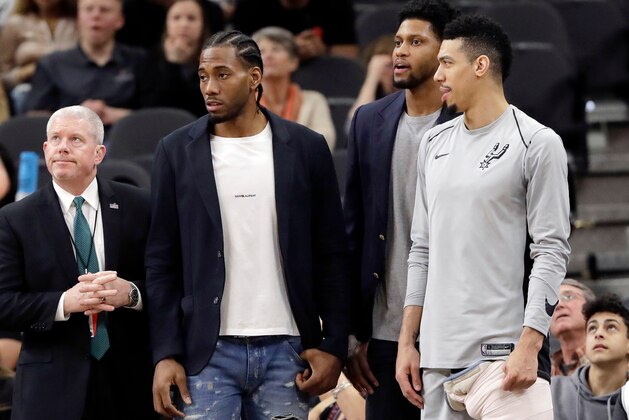 FILE - In this Jan. 21, 2018, file photo, San Antonio Spurs guard Danny Green, right, stands at the bench with injured teammates Kawhi Leonard, second from left, and Rudy Gay, center, during the second half of an NBA basketball game against the Indiana Pacers in San Antonio. General manager R.C. Buford acknowledges star forward Kawhi Leonard is unhappy with the Spurs. He remains optimistic the relationship can be salvaged. (AP Photo/Eric Gay, File)