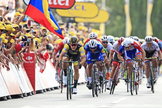 The Colombian flag flies as Netherlands' Dylan Groenewegen, left, crosses the finish line ahead of Colombia's Fernando Gaviria, center, to win the seventh stage of the Tour de France cycling race over 231 kilometers (143.5 miles) with start in Fougeres and finish in Chartres, France, France, Friday, July 13, 2018. (AP Photo/Peter Dejong)