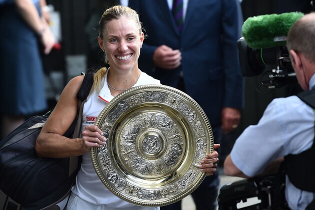 Germany's Angelique Kerber carries the winner's trophy, the Venus Rosewater Dish, as she leaves the court after her women's singles final victory over US player Serena Williams on the twelfth day of the 2018 Wimbledon Championships at The All England Lawn Tennis Club in Wimbledon, southwest London, on July 14, 2018. - Kerber won the match 6-3, 6-3. (Photo by Glyn KIRK / AFP) / RESTRICTED TO EDITORIAL USE        (Photo credit should read GLYN KIRK/AFP/Getty Images)
