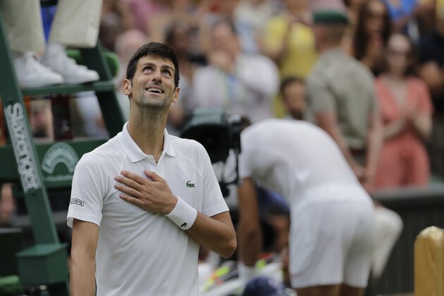 Serbia's Novak Djokovic celebrates defeating Rafael Nadal of Spain, right, during their men's singles semifinals match at the Wimbledon Tennis Championships, in London, Saturday July 14, 2018.(AP Photo/Tim Ireland)