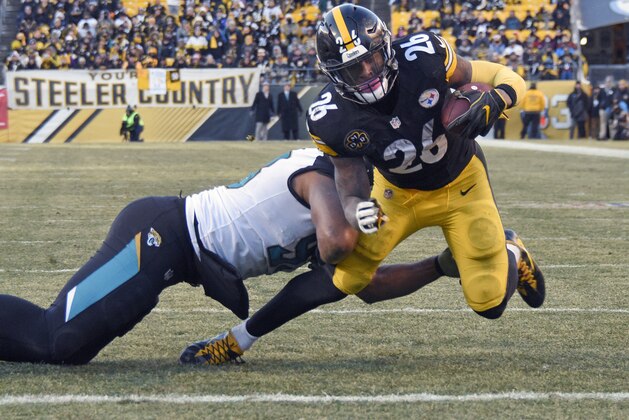 Pittsburgh Steelers running back Le'Veon Bell (26) scores as he is hit byJacksonville Jaguars defensive end Calais Campbell (93) after taking a pass from quarterback Ben Roethlisberger during the second half of an NFL divisional football AFC playoff game in Pittsburgh, Sunday, Jan. 14, 2018. (AP Photo/Don Wright)