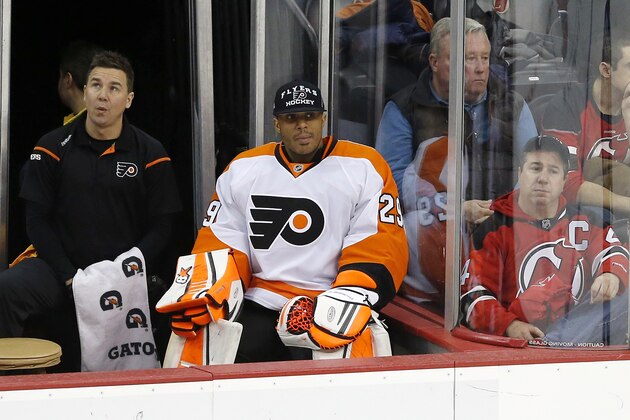 Philadelphia Flyers goalie Ray Emery, center, who was benched after allowing three goals in the first period, watches the third period of an NHL hockey game against the New Jersey Devils, Saturday, Jan. 3, 2015, in Newark, N.J. The Devils won 5-2. (AP Photo/Julio Cortez)