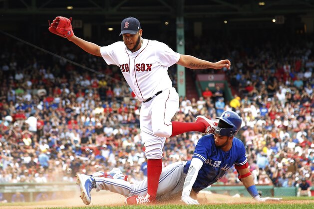 Boston Red Sox starting pitcher Eduardo Rodriguez turns his ankle while trying to avoid Toronto Blue Jays' Lourdes Gurriel Jr. at first base during the sixth inning of a baseball game Saturday, July 14, 2018, in Boston. (AP Photo/Winslow Townson)