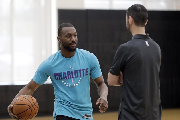 Charlotte Hornets' Kemba Walker, left, talks with head coach James Borrego, right, during pre draft workouts for the NBA basketball team in Charlotte, N.C., Tuesday, June 19, 2018. (AP Photo/Chuck Burton)