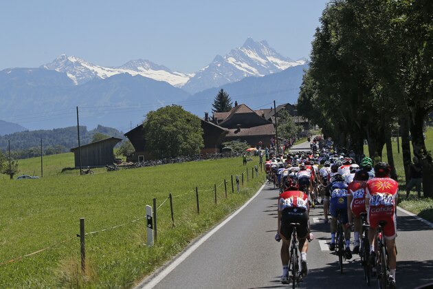 The pack rides towards snow-covered Alps mountain peaks during the seventeenth stage of the Tour de France cycling race over 184.5 kilometers (114.3 miles) with start in Bern and finish in Finhaut-Emosson, Switzerland, Wednesday, July 20, 2016. (AP Photo/Christophe Ena)
