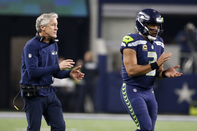 Seattle Seahawks head coach Pete Carroll and quarterback Russell Wilson walk onto the field in the second half of an NFL football game against the Dallas Cowboys on Sunday, Dec. 24, 2017, in Arlington, Texas. (AP Photo/Michael Ainsworth)