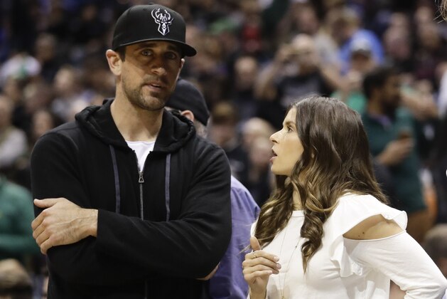 Danica Patrick talks to Green Bay Packers' Aaron Rodgers during the first half of Game 3 of an NBA basketball first-round playoff series between the Milwaukee Bucks and the Boston Celtics Friday, April 20, 2018, in Milwaukee. (AP Photo/Morry Gash)