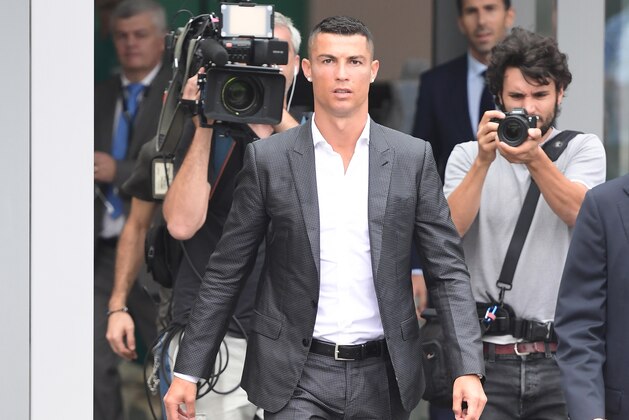 TOPSHOT - Portuguese footballer Cristiano Ronaldo (C) arrives on July 16, 2018 at the Juventus medical centre at the Alliance stadium in Turin. - A Turin hit by Cristiano Ronaldo fever awaits the striker as Juventus prepare to unveil the surprise signing, that after the end of the World Cup, puts all eyes on the Italian champions and Serie A. (Photo by Miguel MEDINA / AFP)        (Photo credit should read MIGUEL MEDINA/AFP/Getty Images)