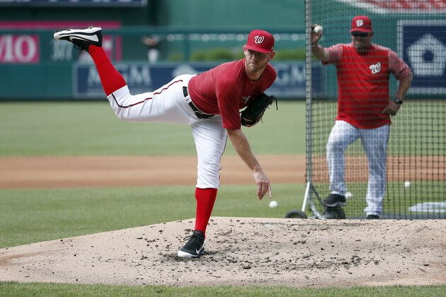 Washington Nationals starting pitcher Stephen Strasburg, left, follows through on a pitch during a pitching workout, as pitching coach Derek Lilliquist watches before a baseball game against the Miami Marlins at Nationals Park, Friday, July 6, 2018, in Washington. (AP Photo/Alex Brandon)