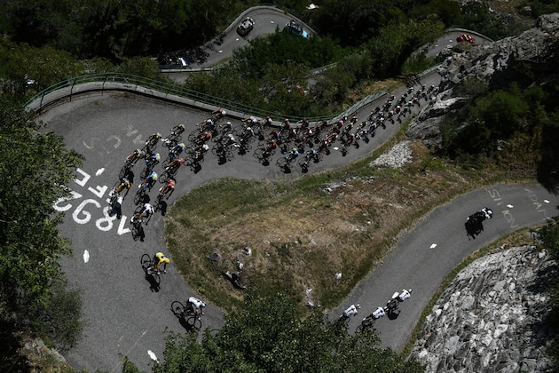 TOPSHOT - The pack, with Great Britain's Geraint Thomas (Front L), wearing the overall leader's yellow jersey, ascends the Montvernier bends during the twelfth stage of the 105th edition of the Tour de France cycling race, between Bourg-Saint-Maurice - Les Arcs and l'Alpe d'Huez, on July 19, 2018. (Photo by Philippe LOPEZ / AFP)        (Photo credit should read PHILIPPE LOPEZ/AFP/Getty Images)