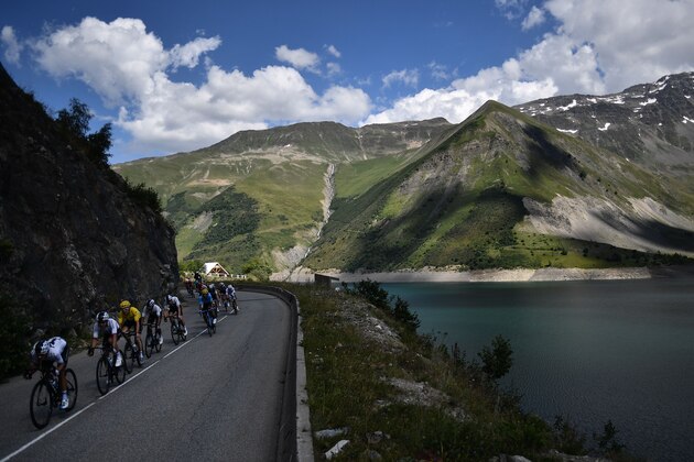 Poland's Michal Kwiatkowski (L) and Great Britain's Geraint Thomas (3rdL), wearing the overall leader's yellow jersey, lead the pack riding down along the Grand'Maison dam and lake during the twelfth stage of the 105th edition of the Tour de France cycling race, between Bourg-Saint-Maurice - Les Arcs and l'Alpe d'Huez, on July 19, 2018. (Photo by Jeff PACHOUD / AFP)        (Photo credit should read JEFF PACHOUD/AFP/Getty Images)