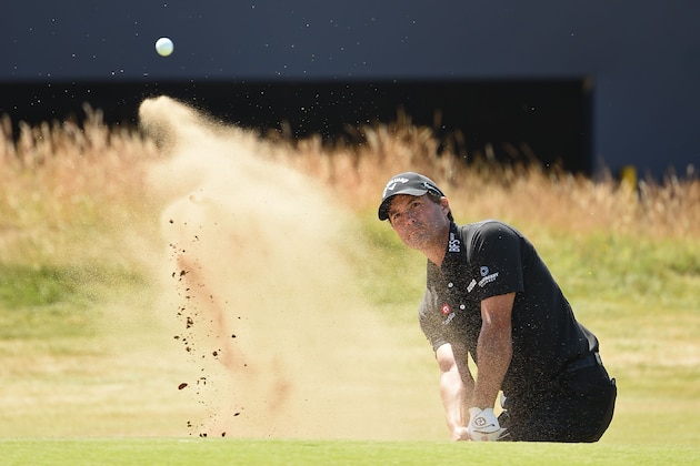 TOPSHOT - US golfer Kevin Kisner plays out of a green-side bunker on the 18th hole during his first round 66 on day one of The 147th Open golf Championship at Carnoustie, Scotland on July 19, 2018. (Photo by Paul ELLIS / AFP)        (Photo credit should read PAUL ELLIS/AFP/Getty Images)