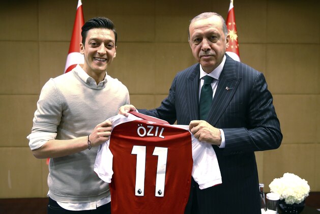 In this photo taken on Sunday, May 13, 2018, Turkey's President Recep Tayyip Erdogan, right, poses for a photo with Turkish-German Arsenal soccer player Mesut Ozil in London. Erdogan started a three-day visit to Britain on Sunday by praising the country as