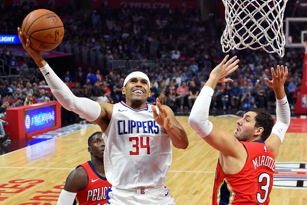 Los Angeles Clippers forward Tobias Harris, center, shoots as New Orleans Pelicans forward Nikola Mirotic, right, of Montenegro, defends during the first half of an NBA basketball game, Monday, April 9, 2018, in Los Angeles. (AP Photo/Mark J. Terrill)