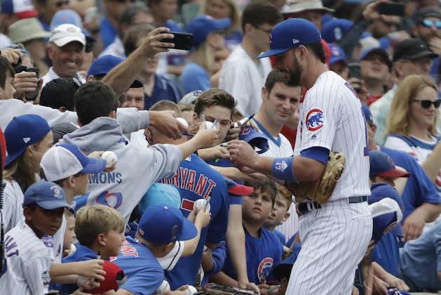 Chicago Cubs' Kris Bryant, right, autographs for fans before a baseball game against the St. Louis Cardinals, Sunday, July 22, 2018, in Chicago. (AP Photo/Nam Y. Huh)
