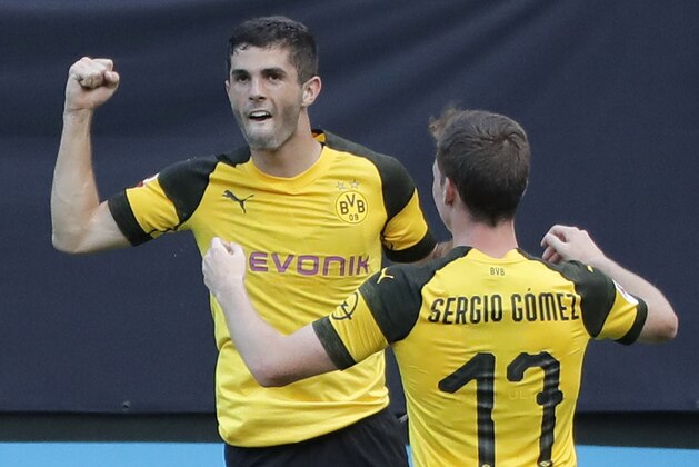 Borussia Dortmund's Christian Pulisic, left, celebrates with Sergio Gomez (17) after scoring a goal against Liverpool during the second half of an International Champions Cup tournament soccer match in Charlotte, N.C., Sunday, July 22, 2018. (AP Photo/Chuck Burton)