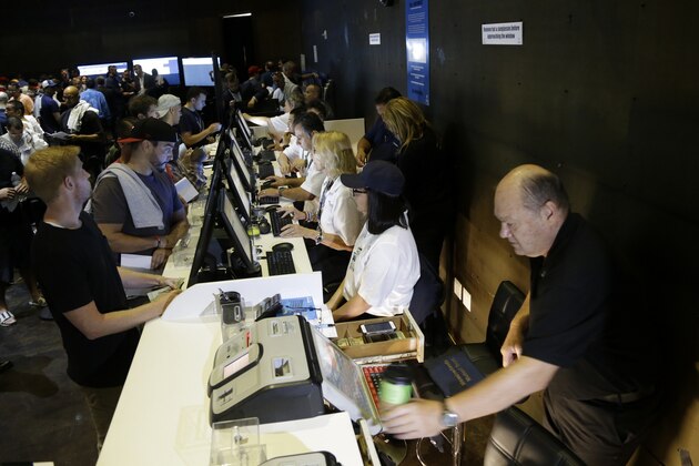 People, left, place bets at the Meadowlands Racetrack, Saturday, July 14, 2018, in East Rutherford, N.J. Meadowlands Racetrack started taking sports betting on Saturday, becoming the fourth sports betting outlet in New Jersey following the state's U.S. Supreme Court victory in a case that cleared the way for all 50 states to legalize sports betting. (AP Photo/Julio Cortez)