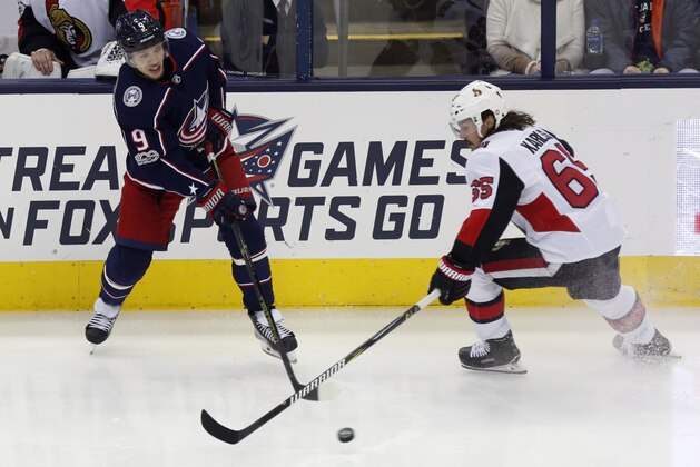 Columbus Blue Jackets forward Artemi Panarin, left, of Russia, passes the puck against Ottawa Senators defenseman Erik Karlsson, of Sweden, during an NHL hockey game in Columbus, Ohio, Friday, Nov. 24, 2017. The Blue Jackets won 5-2. (AP Photo/Paul Vernon)