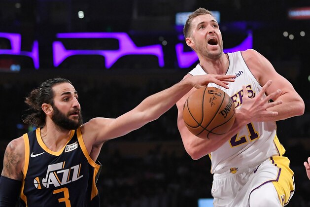 Utah Jazz guard Ricky Rubio, left, of Spain, reaches in against Los Angeles Lakers forward Travis Wear as Wear tried to shoot during the first half of an NBA basketball game Sunday, April 8, 2018, in Los Angeles. (AP Photo/Mark J. Terrill)