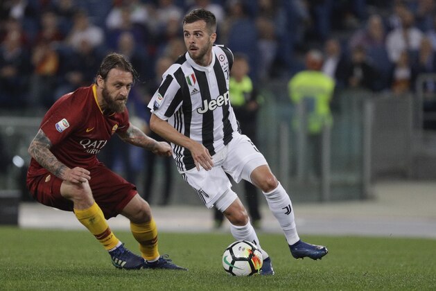 Juventus' Miralem Pjanic, right, is challenged by Roma's Daniele De Rossi during a Serie A soccer match between Roma and Juventus, at the Rome Olympic stadium, Sunday, May 13, 2018. (AP Photo/Gregorio Borgia)