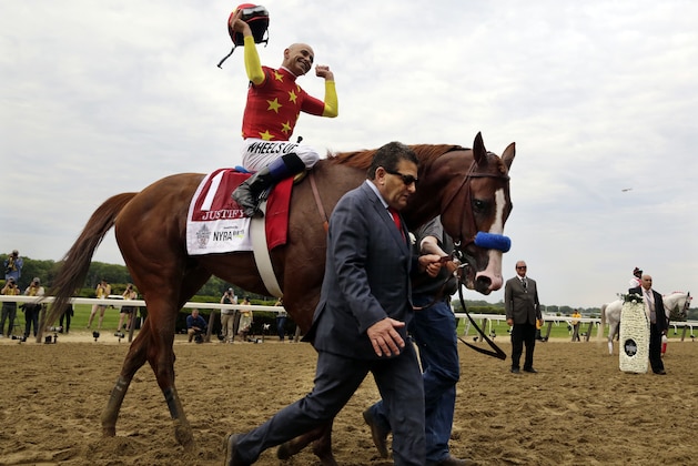 Assistant trainer Jimmy Barnes leads Justify to the winner's circle as jockey Mike Smith celebrates after winning the Triple Crown at the150th running of the Belmont Stakes horse race, Saturday, June 9, 2018, in Elmont, N.Y. (AP Photo/Peter Morgan)