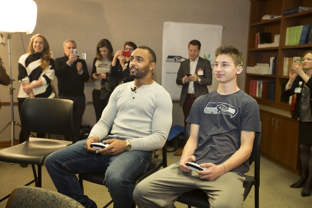 IMAGE DISTRIBUTED FOR CENTURYLINK - CenturyLink and Seattle Seahawks wide receiver Doug Baldwin shared a home team connection to deliver a Boostbox to Max Cohen, a 15-year-old patient at Virginia Mason Hospital, and play a game of Madden NFL, Tuesday, Nov. 28, 2017 in Seattle. Cohen, who was born deaf, has powered through several surgeries to regain his sense of hearing thanks to cochlear implants. Fans can win their very own Seahawks Boostbox full of new prizes through the end of the season by visiting seahawks.com/centurylink. (Ron Wurzer/AP Images for CenturyLink)