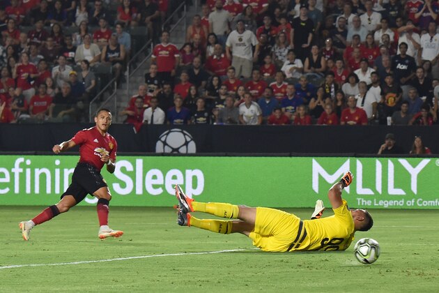 Manchester United's Chilean striker Alexis Sanchez (L) scores a goal past AC Milan's goalkeeper from Italy Gianluigi Donnarumma during the International Champions Cup match between Manchester United and AC Milan at the StubHub Center in Carson, California, on July 25, 2018. (Photo by Robyn Beck / AFP)        (Photo credit should read ROBYN BECK/AFP/Getty Images)