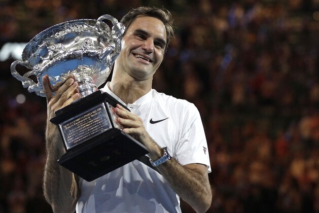 FILE - In this Jan. 28, 2018, file photo, Switzerland's Roger Federer holds his trophy after defeating Croatia's Marin Cilic during the men's singles final at the Australian Open tennis championships in Melbourne, Australia. Federer, who turns 37 in less than two months, seems to stay forever young. (AP Photo/Dita Alangkara, File)