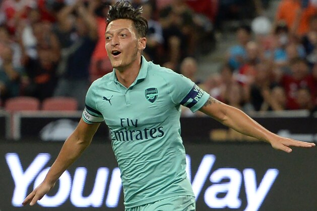 Mesut Ozil of Arsenal celebrates after scoring during the International Champions Cup football match between Arsenal and Paris Saint-Germain in Singapore on July 28, 2018. (Photo by ROSLAN RAHMAN / AFP)        (Photo credit should read ROSLAN RAHMAN/AFP/Getty Images)