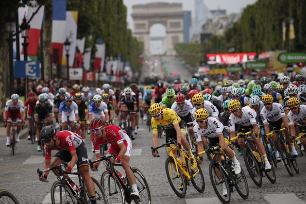 The pack rides on the Champs Elysees avenue as the Arc de Triomphe is seen in the background during the twenty-first and last stage of the Tour de France cycling race over 103 kilometers (64 miles) with start in Montgeron and finish in Paris, France, Sunday, July 23, 2017. (AP Photo/Christophe Ena)