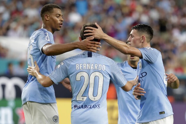 Manchester City midfielder Bernardo Silva (20) is congratulated by teammates after scoring a goal during the first half of an International Champions Cup tournament soccer match against FC Bayern, Saturday, July 28, 2018, in Miami Gardens, Fla. (AP Photo/Lynne Sladky)