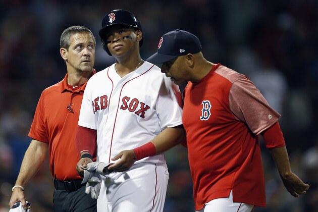 Boston Red Sox's Rafael Devers, center, walks off the field with manager Alex Cora, right, during the eighth inning of a baseball game against the Minnesota Twins in Boston, Saturday, July 28, 2018. (AP Photo/Michael Dwyer)