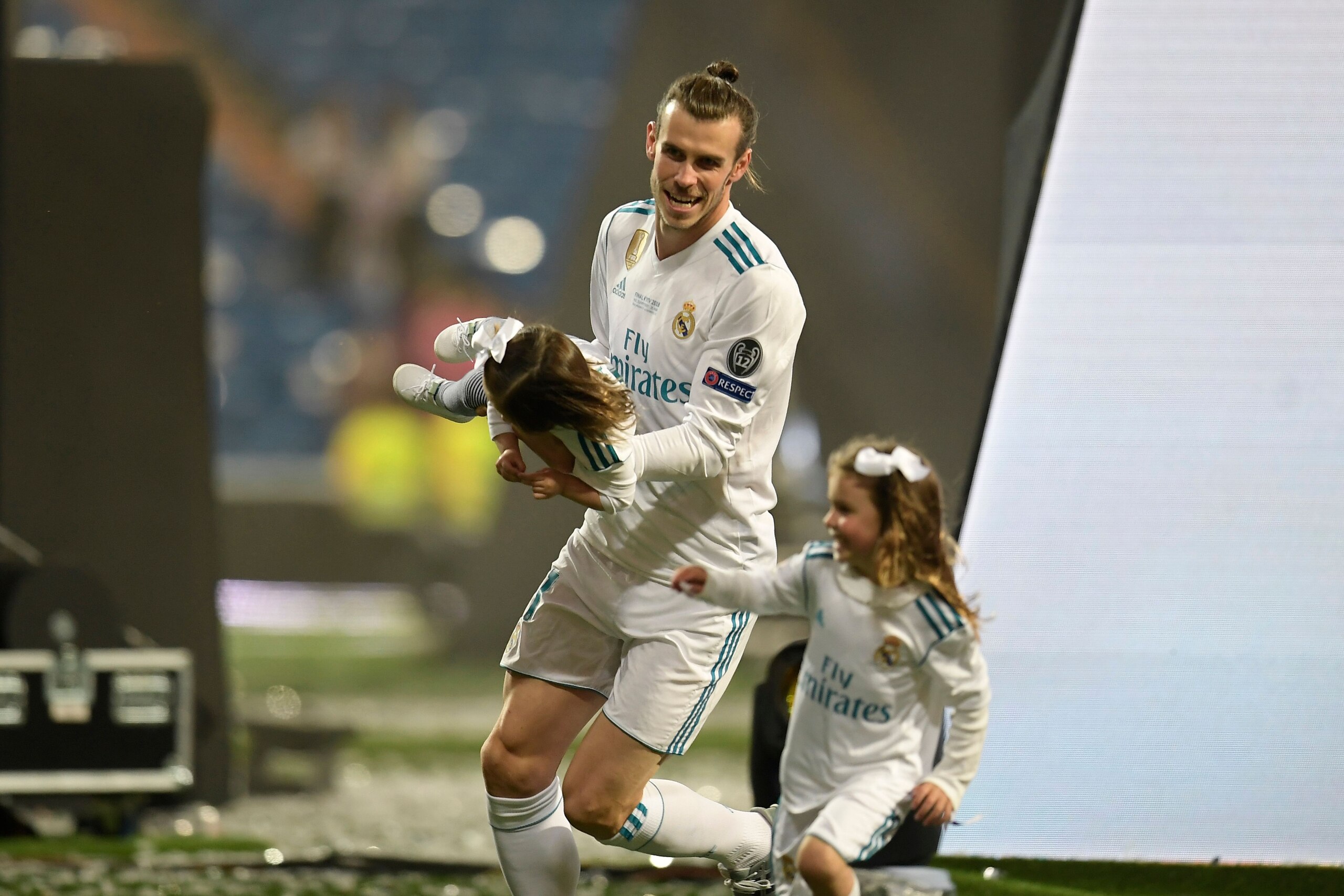 Real Madrid's Welsh forward Gareth Bale plays with his daughters at the Santiago Bernabeu stadium in Madrid on May 27, 2018 during a victory ceremony after Real Madrid won its third Champions League title in a row in Kiev. (Photo by OSCAR DEL POZO / AFP)        (Photo credit should read OSCAR DEL POZO/AFP/Getty Images)
