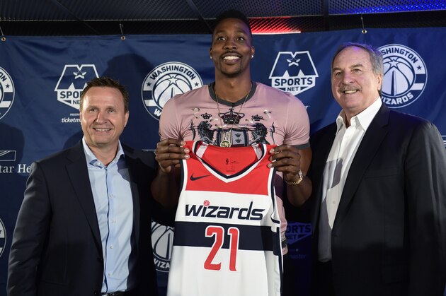 Washington Wizards recently acquired center Dwight Howard, center, flanked by Wizards coach Scott Brooks, left, and Wizards President Ernie Grunfeld, right, pose for a photo during a news conference in Washington, Monday, July 23, 2018. Howard, an eight-time All-Star, averaged 16.6 points per game and 12.5 rebounds last season with the Charlotte Hornets. (AP Photo/Susan Walsh)