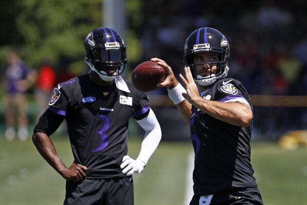Baltimore Ravens quarterback Joe Flacco, right, throws a pass in front of quarterback Robert Griffin III during an NFL football training camp practice at the team's headquarters in Owings Mills, Md., Thursday, July 19, 2018. (AP Photo/Patrick Semansky)