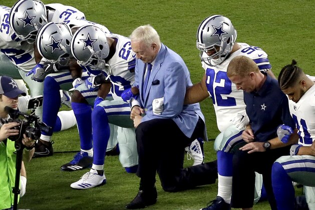 FILE - In this Monday, Sept. 25, 2017, file photo, the Dallas Cowboys, led by owner Jerry Jones, center, take a knee prior to the national anthem and an NFL football game against the Arizona Cardinals, in Glendale, Ariz. ESPN anchor Jemele Hill has been suspended by the network for two weeks for making political statements on social media.  Hill, who is African-American, received criticism from the network last month after referring to President Donald Trump as a