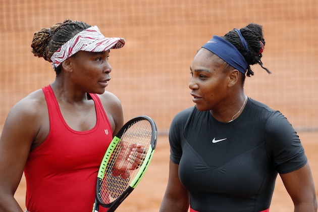 Serena Williams of the U.S., right, and her sister Venus Williams talk during their doubles second round match of the French Open tennis tournament against Italy's Sara Errani and Belgium's Kirsten Flipkens at the Roland Garros stadium, Friday, June 1, 2018 in Paris. (AP Photo/Christophe Ena)