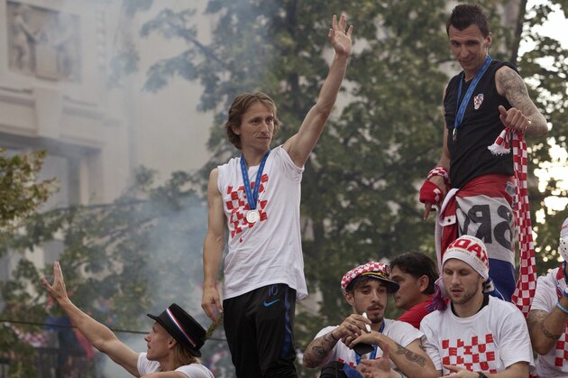 Croatia's national soccer team members, from left, Domagoj Vida, Luka Modric, Sime Vrsaljko, Ante Rebic and Mario Mandzukic, are seen on top of an open bus as they are greeted by fans during a celebration in central Zagreb, Croatia, Monday, July 16, 2018. In an outburst of national pride and joy, Croatia rolled out a red carpet and staged a euphoric heroes' welcome for the national team on Monday despite its loss to France in the World Cup final. (AP Photo/Marko Drobnjakovic)