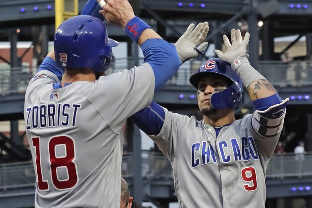 Chicago Cubs' Javier Baez (9) is greeted by Ben Zobrist (18) as he crosses home plate after hitting a three-run home run off Pittsburgh Pirates starting pitcher Jameson Taillon during the fourth inning of a baseball game in Pittsburgh, Tuesday, July 31, 2018. (AP Photo/Gene J. Puskar)